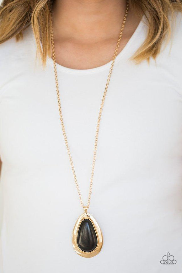 Paparazzi BADLAND To The Bone - Gold A dramatic black stone teardrop is pressed into a glistening gold frame radiating with rustic patterns. The impressive pendant swings from the bottom of a lengthened gold chain for a seasonal look. Features an adjustable clasp closure.

