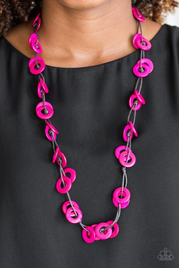 Paparazzi Waikiki Winds - Pink Shiny brown cording knots around vivacious pink wooden discs, creating a colorful display across the chest. Features a button loop closure.

