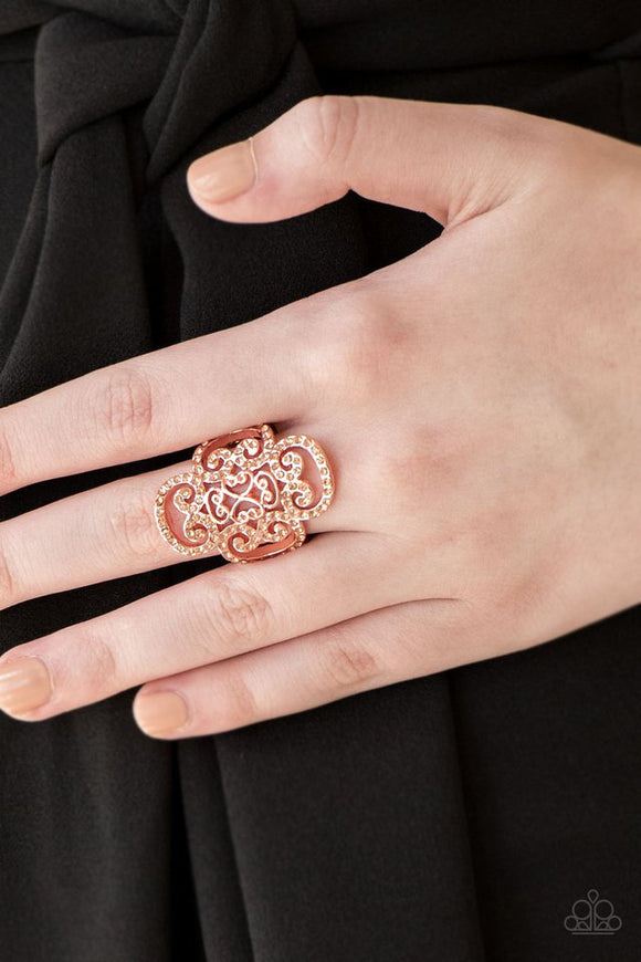 Paparazzi Regal Regalia - Copper - Ring  -  Dainty peach rhinestones are encrusted along a shiny copper frame radiating with regal filigree for a refined look. Features a stretchy band for a flexible fit.
