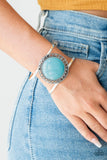 Paparazzi RODEO Rage - Blue - Set  -  A turquoise stone is pressed into the center of a shimmery silver frame radiating with sunburst details. The earthy frame sits atop an airy silver cuff for a seasonal finish.
