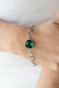 Paparazzi All Aglitter - Green  -  A dramatic green gem attaches to a shiny silver chain, creating a blinding centerpiece atop the wrist. Features a toggle closure.
