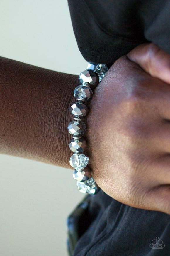 Paparazzi Beautifully Bewitching - Silver
Faceted hematite and smoky crystal-like gems are threaded along a stretchy band, gradually increasing in size near the center for a dramatic finish. 