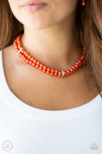 Paparazzi Put On Your Party Dress - Orange - Necklace  -  Pinched between white rhinestone encrusted frames, strands of classic orange pearls layer around the neck for a timeless look. Features an adjustable clasp closure.
