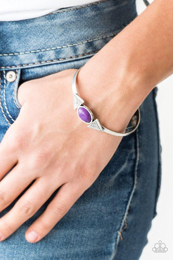 Paparazzi Apache Trail - Purple A smooth purple stone is pressed into the center of a dainty silver cuff. Stamped in geometric patterns, a pair of silver triangular frames flank the stone centerpiece for a tribal inspired finish.

