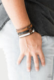 Paparazzi Grizzly Ground - Multi Strips of black, brown, and white leather are laced through a thick brown leather band radiating with gunmetal studs for a rugged look. Features an adjustable snap closure.

