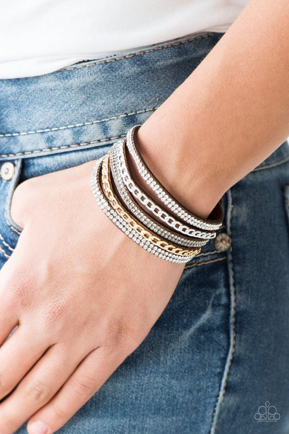 Paparazzi Fashion Fiend - Brown - Bracelet  -  Glassy white and smoky rhinestones are encrusted along strands of brown suede. Glistening silver and gold chains are added to the bands, adding edgy industrial shimmer to the sassy palette. Features an adjustable snap closure.

