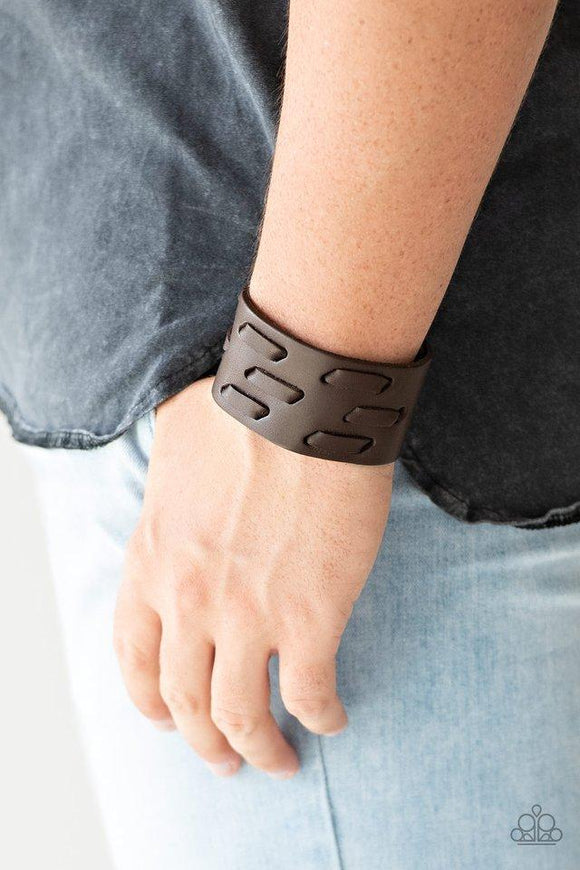 Paparazzi Be Your Own HUNTSMAN - Brown  -  Brown leather cording is laced across the front of a thick leather band, creating a rugged look around the wrist. Features an adjustable snap closure.
