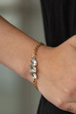 Paparazzi Pretty Priceless - Gold - Bracelet  -  Featuring regal marquise-cuts, a trio of glittery white rhinestones join across the center of the wrist for a timeless look. Features an adjustable clasp closure.
