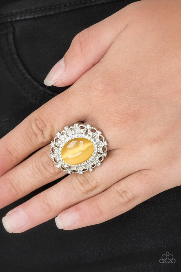 Paparazzi BAROQUE The Spell - Yellow - Ring  -  Encrusted in dainty white rhinestones, a frilly silver frame spins around a glowing yellow moonstone center for a regal look. Features a stretchy band for a flexible fit.
