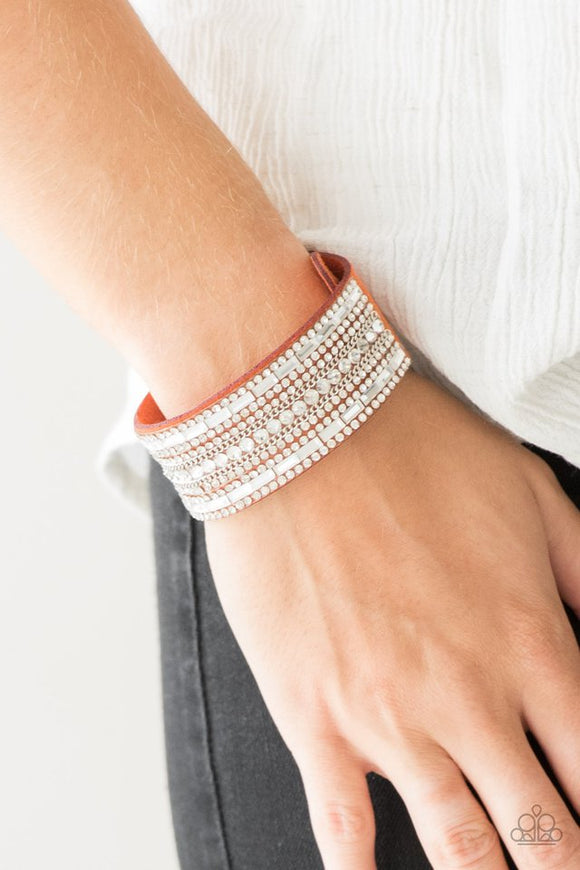 Paparazzi Rebel Radiance - Orange - Bracelet  -  Featuring classic round and edgy emerald style cuts, glittery white rhinestones and glistening silver chains are encrusted along bands of orange suede for a sassy look. Features an adjustable snap closure.
