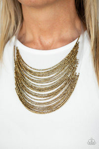 Paparazzi Catwalk Queen - Brass Strand after strand of shimmering brass seed beads fall together to create a bold statement piece. Features an adjustable clasp closure.

