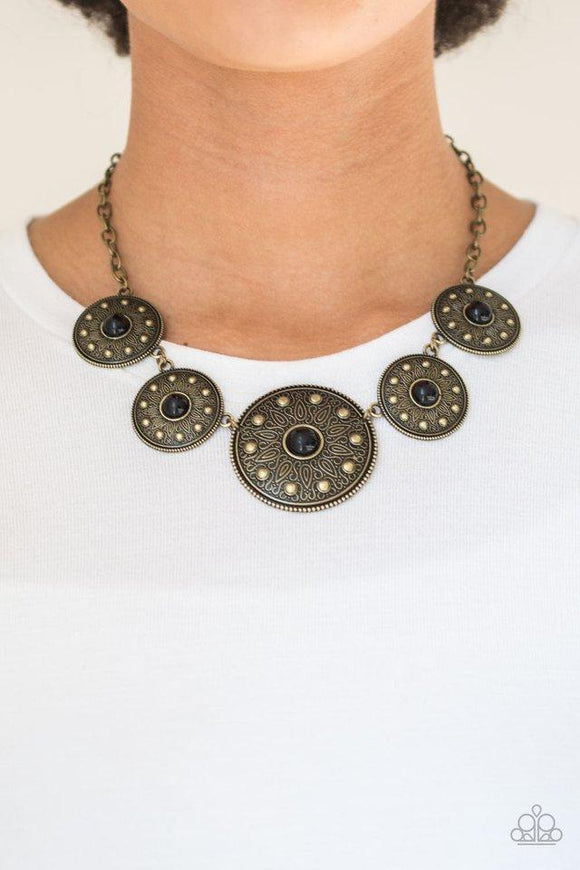 Paparazzi Hey SOL Sister - Black Gradually increasing in size near the center, round brass frames radiating with sunburst patterns link below the collar. Infused with shiny brass studs, the tribal inspired frames are dotted with black beaded centers for a colorful finish. Features an adjustable clasp closure.

