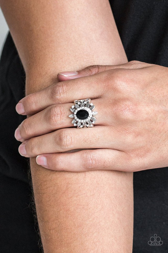 Paparazzi Burn Bright - Black - Ring  -  Ringed in glittery white rhinestones, a sparkling black gem is pressed into the center of a leafy silver frame. Dainty white rhinestones are sprinkled along the shimmery foliage for a refined finish. Features a stretchy band for a flexible fit.
