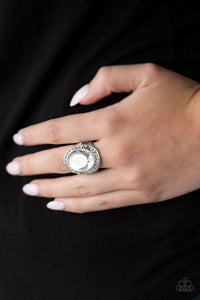 Paparazzi Queen Scene - White  -  A dramatic white gem is pressed into a round silver frame radiating with glassy white rhinestones for a statement-making finish. Features a stretchy band for a flexible fit.
