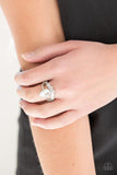 Paparazzi If The Crown Fits - White A shiny silver bar and white rhinestone encrusted bar arc across the finger, coalescing into an airy band. Featuring a regal teardrop cut, a glittery white rhinestone is pressed into the bands for a statement making finish. Features a dainty stretchy band for a flexible fit.


