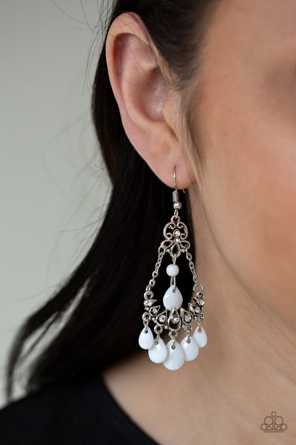 Paparazzi Malibu Sunset - White Faceted white teardrop beads swing from the top and bottom of an ornate silver frames suspended by chains. Dainty white rhinestones are sprinkled across the silver teardrop filigree dcor for a whimsical finish. Earring attaches to a standard fishhook fitting.
