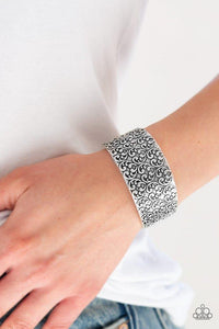 Paparazzi Eat Your Heart Out - Silver Brushed in an antiqued shimmer, a vintage inspired heart pattern is embossed across the front of a thick silver cuff for a flirty look.

