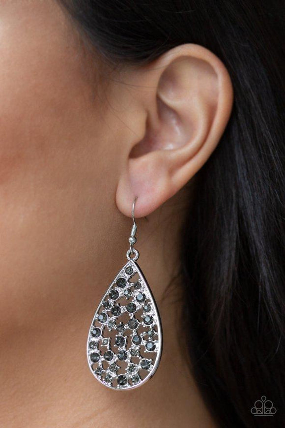 Paparazzi Call Me Ms. Universe - Silver  -  Hints of silver frames and smoky rhinestones collect inside an airy silver teardrop, creating a gorgeous lure. Earring attaches to a standard fishhook fitting.
