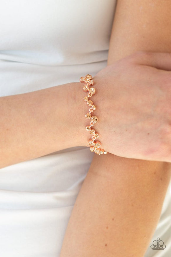 Paparazzi Starlit Stunner - Copper - Bracelet  -  Varying in size, a collection of rhinestones connect across the wrist for a timeless look. Features an adjustable clasp closure.
