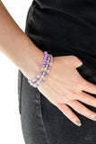 Paparazzi Irresistibly Irresistible - Purple A collection of polished purple, shiny silver, and faceted crystal-like beads are threaded along stretchy bands, creating colorful layers around the wrist.

