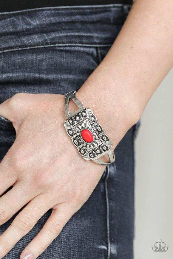 Paparazzi BIG House On The Prairie - Red Embossed in sunburst patterns, a rectangular silver frame sits atop a bangle-like cuff for a seasonal flair. A fiery red stone is pressed into the center for a colorful finish. Features a hinged closure.
