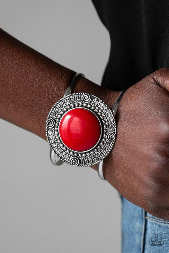 Paparazzi Tribal Pop - Red An oversized red bead is pressed into the center of a round silver frame radiating with swirly filigree detail. The bold frame sits atop an airy silver cuff for a vibrant pop of color.

