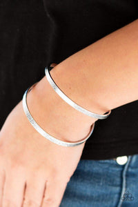 Paparazzi Grenada Goddess- Silver Delicately hammered in shimmer, glistening silver bars arc across the wrist, coalescing into an airy cuff.

