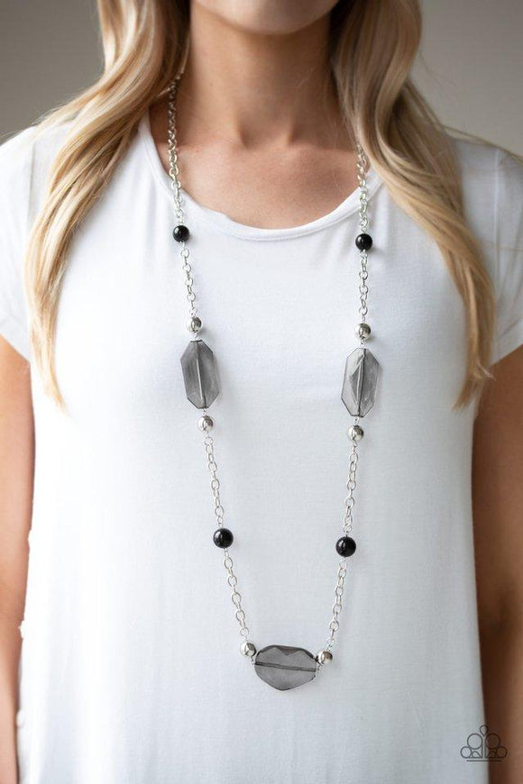 Paparazzi Crystal Charm - Black  -  A collection of polished black beads, shiny silver beads, and oversized faceted crystal-like beads trickle along a shimmery silver chain across the chest for a whimsically refined look. Features an adjustable clasp closure.
