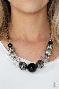 Paparazzi Sugar, Sugar - Black A collection of antiqued silver beads, smoky crystal-like beads, and oversized black beads are threaded along an invisible wire below the collar. Textured in linear patterns, an antiqued silver chain attaches to the colorful compilation for a statement-making finish. Features an adjustable clasp closure.
