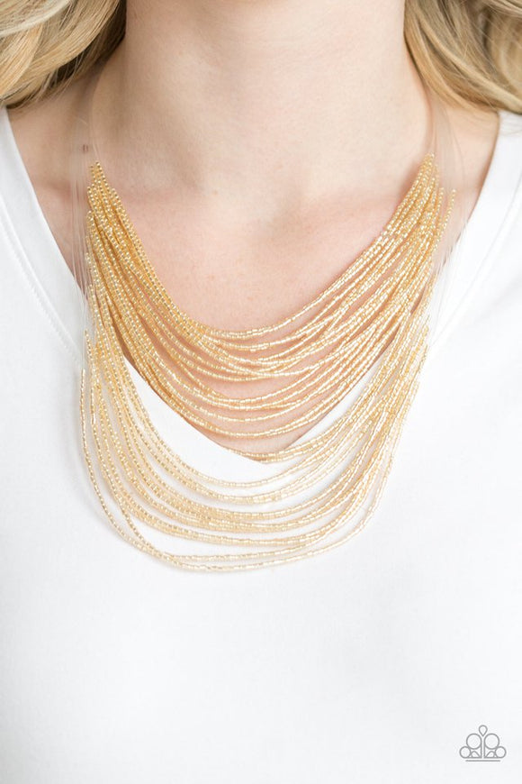 Paparazzi Catwalk Queen - Gold - Necklace  -  Strand after strand of metallic gold seed beads fall together to create a bold statement piece. Features an adjustable clasp closure.
