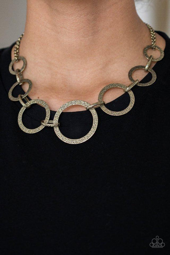 Paparazzi City Circus - Brass  -  Delicately hammered in antiqued shimmer, glistening brass hoops connect with ornate links below the collar for an edgy look. Features an adjustable clasp closure.
