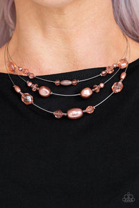 Paparazzi Pacific Pageantry - Copper  -  An elegant collection of pearly copper beads and sparkling crystal-like beads are fitted in place along three silver wires below the collar, creating the illusion of floating layers. Features an adjustable clasp closure.
