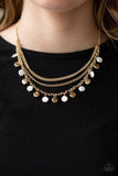 Paparazzi Beach Flavor - Gold  -  Mismatched gold chains layer below the collar. Shell-like white beads and shiny gold beads trickle from the lowermost chain, creating an iridescent fringe. Features an adjustable clasp closure.
