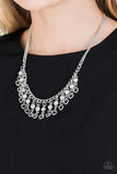 Paparazzi Valentines Day Drama - White A row of shimmery silver hearts and glittery white rhinestones swing from the bottom of a glistening silver fringe, creating a flirty fringe below the collar. Features an adjustable clasp closure.

