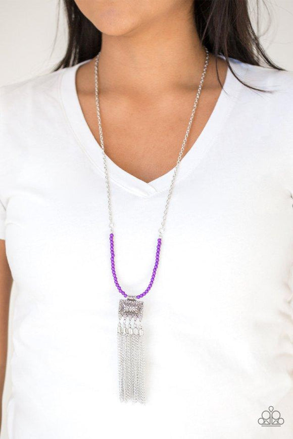 Paparazzi Mayan Masquerade - Purple Attached to the bottom of a shimmery silver chain, a row of dainty purple beads gives way to an ornate silver frame radiating with a beaded silver chain fringe for an adventurous look. Features an adjustable clasp closure.
