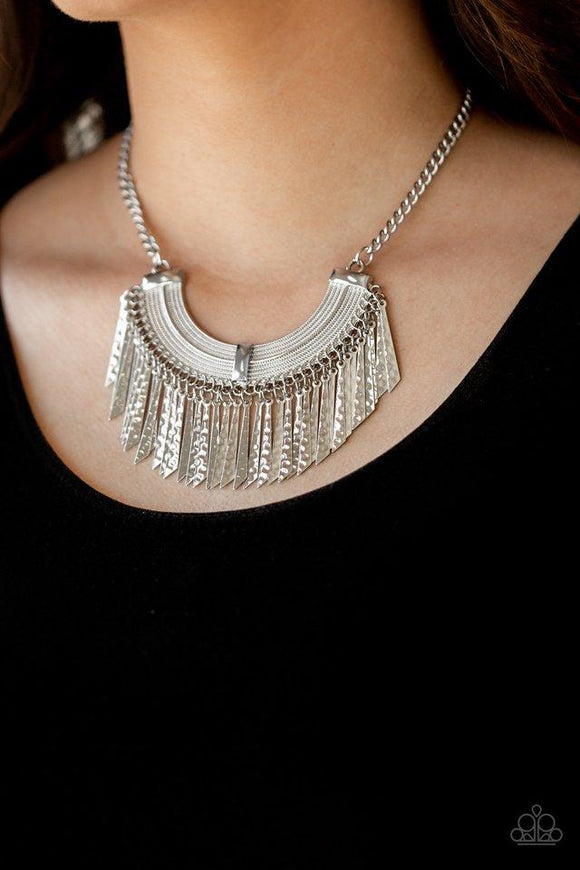 Paparazzi Impressively Incan - Silver  -  Hammered in shimmery textures, flared silver plates swing from the bottom of an ornate half-moon frame, creating an edgy fringe below the collar. Features an adjustable clasp closure.
