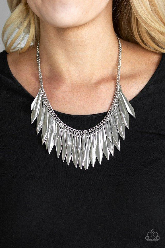 Paparazzi The ThrillSeeker- Silver A collection of flared silver daggers swing from the bottom of a glistening silver chain, creating an edgy fringe below the collar. Featuring a subtle crease down the center, the shimmery discs gradually increase in size as they drip from the chain, adding an irresistible industrial flair to the look. Features an adjustable clasp closure.


