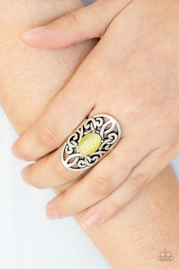 Paparazzi GLEAM Big - Yellow  -  A glowing yellow cat's eye stone is pressed into the center of an oval backdrop swirling with vine-like filigree for a whimsical look. Features a stretchy band for a flexible fit.
