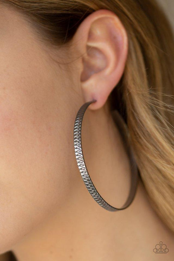 Paparazzi Retro Rebellion - Black  -  Stamped in dizzying textures, a glistening gunmetal bar curls into an oversized hoop for a retro look. Earring attaches to a standard post fitting. Hoop measures approximately 2 3/4