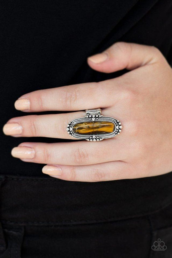 Paparazzi Desert Tranquility - Brown Featuring an oblong shape, a glassy tiger's eye stone bead is pressed into a studded silver frame atop the finger for a seasonal flair. Features a stretchy band for a flexible fit.
