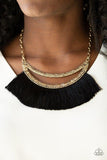 Paparazzi The MANE Event - Gold A Plume of shiny black thread flares out from the bottom of an airy half-moon frame stamped in tribal inspired patterns, creating a bold fringe below the collar. Features an adjustable clasp closure.
