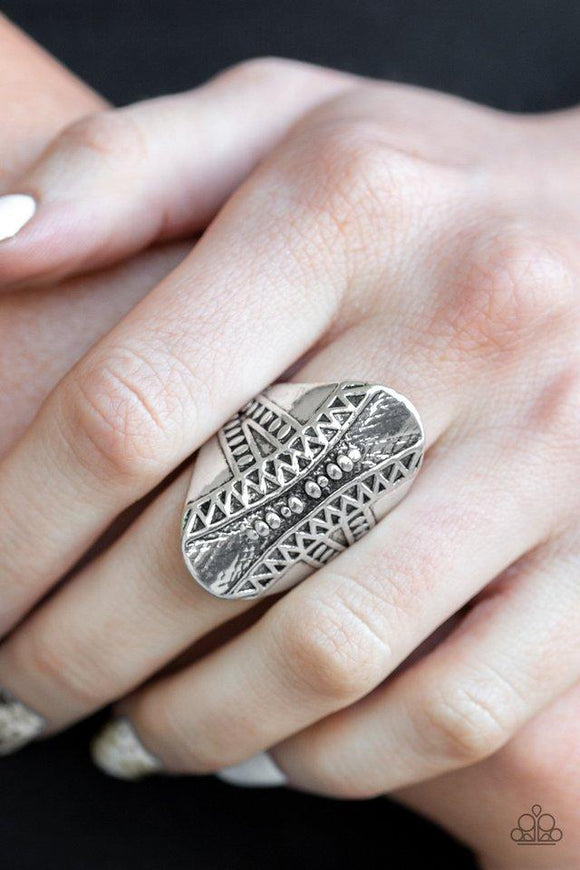 Paparazzi Shields Up - Silver Studded and embossed in shimmery triangular patterns, a thick oval frame folds around the finger for a bold tribal look. Features a stretchy band for a flexible fit.
Featured inside The Preview at ONE Life!

