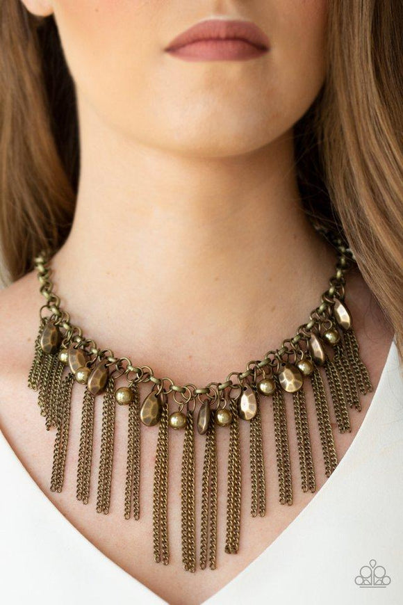 Paparazzi Industrial Intensity - Brass A collection of faceted brass teardrops and pearly brass beads drip from the bottom of an antiqued brass chain. Pairs of brass chains stream from the bottom of the chain, creating an intensely tapered fringe below the collar. Features an adjustable clasp closure.
