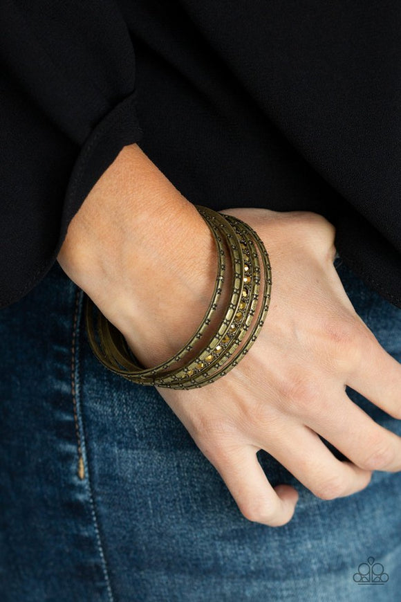 Paparazzi Glitzy Grunge - Brass - Bracelet  -  A single aurum rhinestone encrusted bangle joins four textured brass bangles, creating an edgy stack of shimmer across the wrist.
