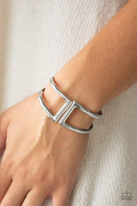 Paparazzi Geo Glam - Silver Brushed in a high-sheen shimmer, geometric silver frames curl around the wrist, creating a tribal inspired cuff. Features a hinged closure.
