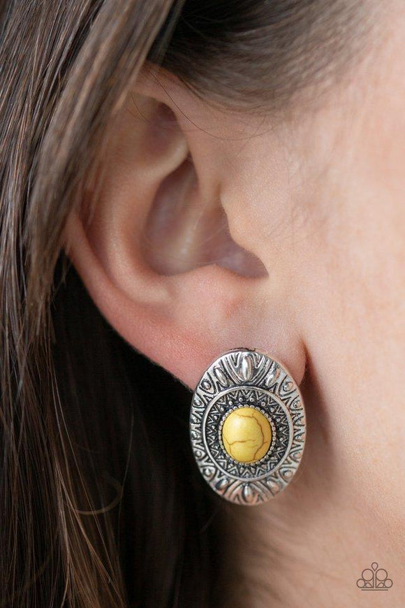 Paparazzi Stone Tiki - Yellow  -  A sunny yellow stone is pressed into the center of an ornate silver frame radiating with sunburst and studded patterns for a tribal inspired look. Earring attaches to a standard post fitting.

