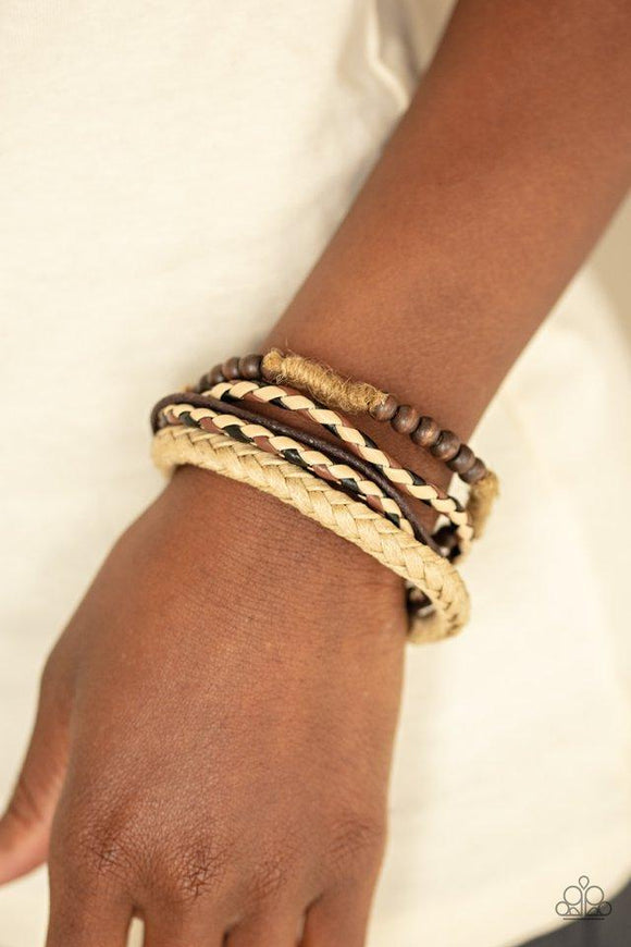 Paparazzi Woodland Wayfarer - Brown  -  Mismatched strands of brown cording, braided leather, braided twine, and a wooden beaded bracelet layer across the wrist for an earthy look. Features an adjustable sliding knot closure.
