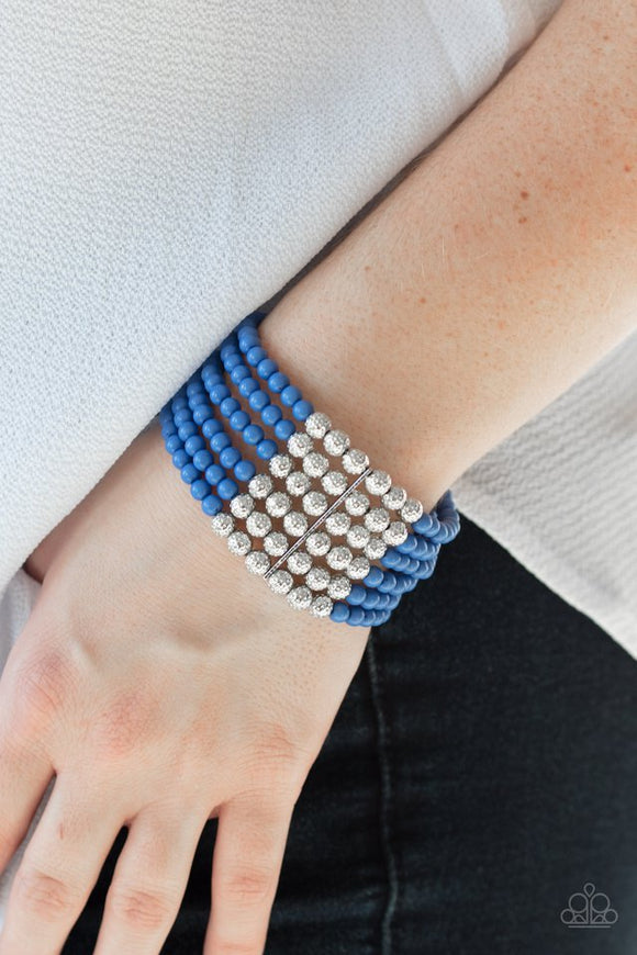 Paparazzi LAYER It On Thick - Blue  -  Held together with silver fittings, row after row of ornate silver and polished blue beads are threaded along stretchy bands around the wrist of a colorful fashion.
