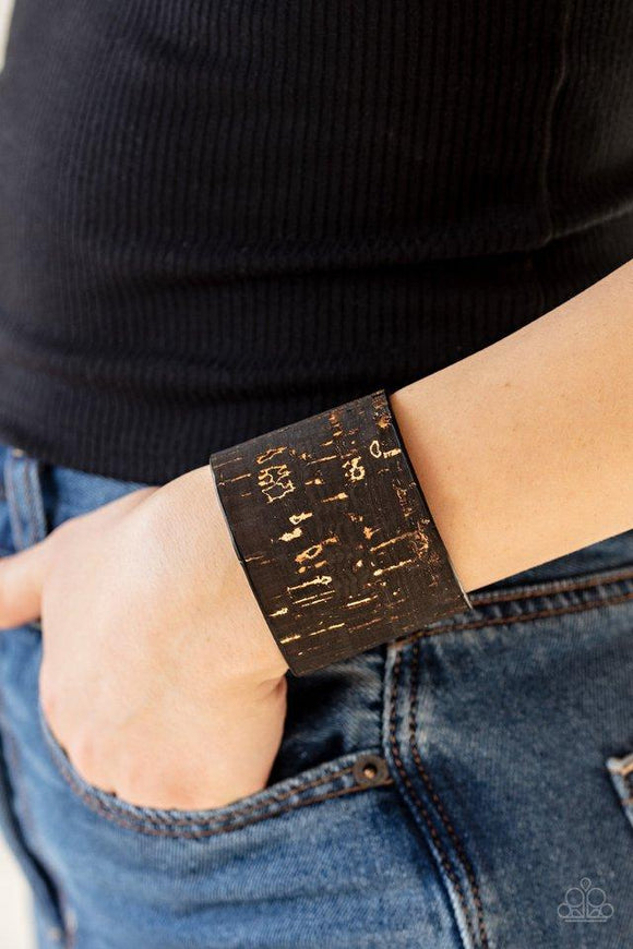 Paparazzi Up To Scratch - Black  -  Featuring a black cork-like finish, a thick cuff is scratched, revealing lines of golden shimmer for a seasonal look.
