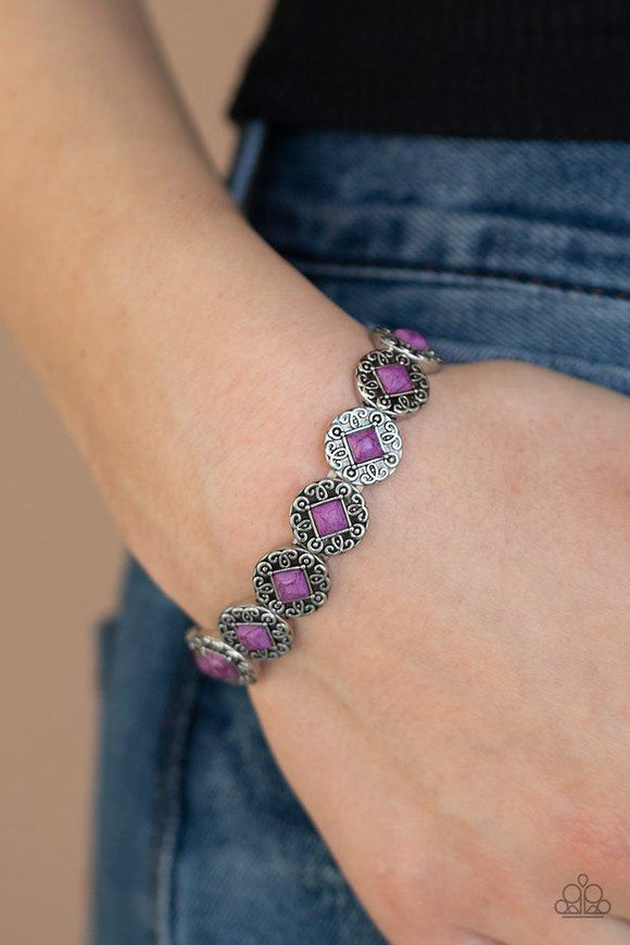 Paparazzi Desert Dilemma - Purple  -  Featuring square purple stone centers, ornate silver frames are threaded along a stretchy band around the wrist for a seasonal flair.
